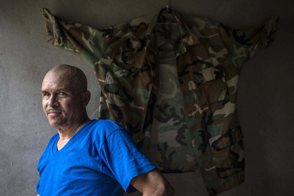 Reynaldo Esquivel, ex Cachorro del BLI Ramón Raudales, posa junto a un uniforme de la contra que obtuvo durante la guerra. Foto: Óscar Navarrete / La Prensa.